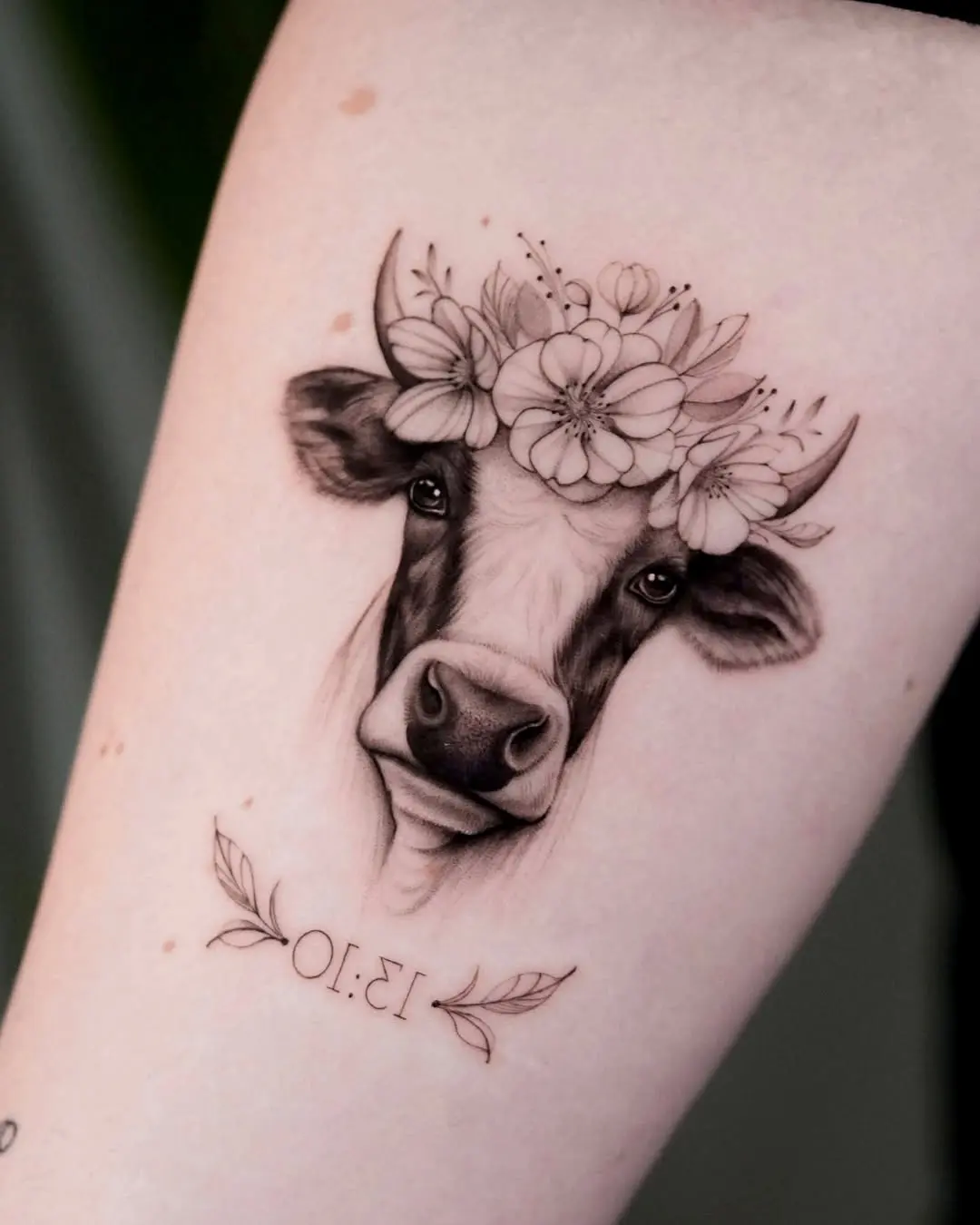 Whimsical cow tattoo adorned with flowers