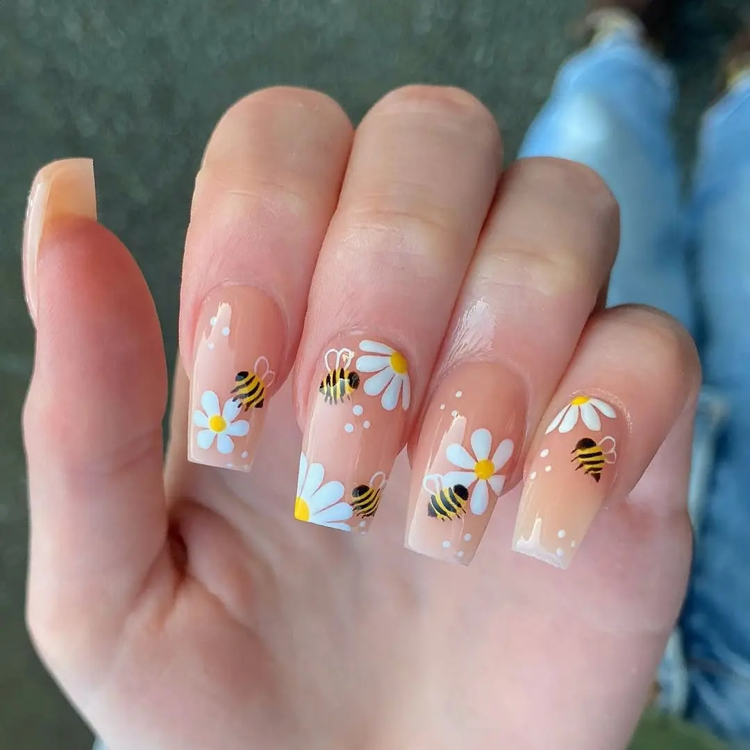 Charming bee-themed nail art with floral accents