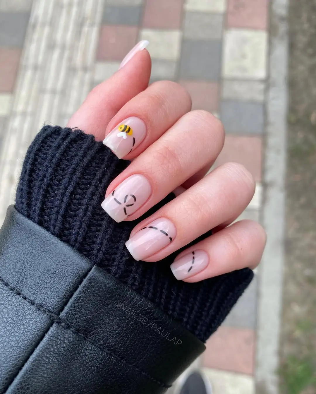 Charming bee-themed French tip nail design