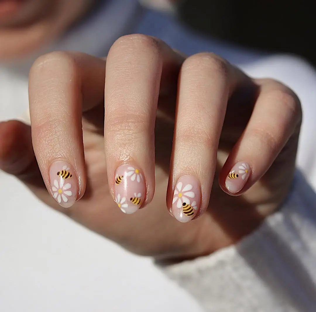 Charming bee-themed nail art with floral accents
