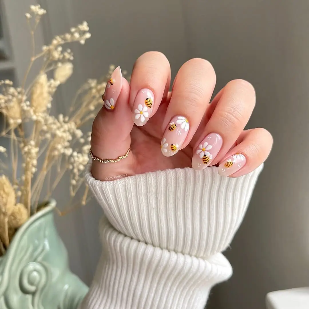 Charming bee-themed nails with floral accents