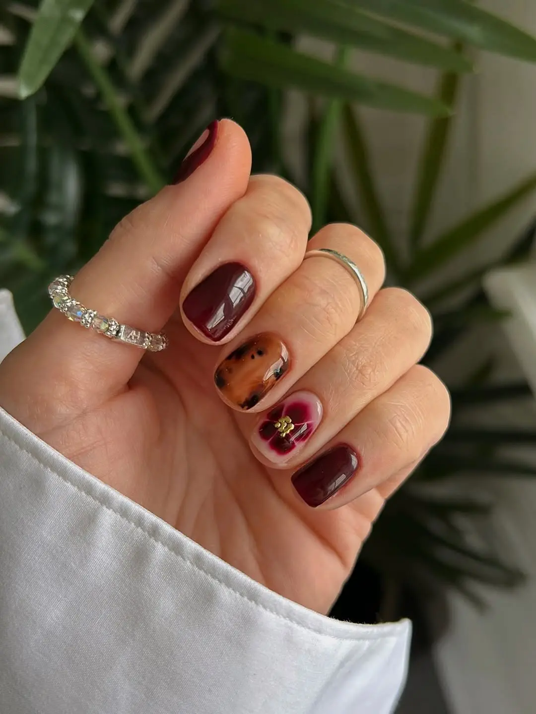 Chic burgundy nails with floral accents