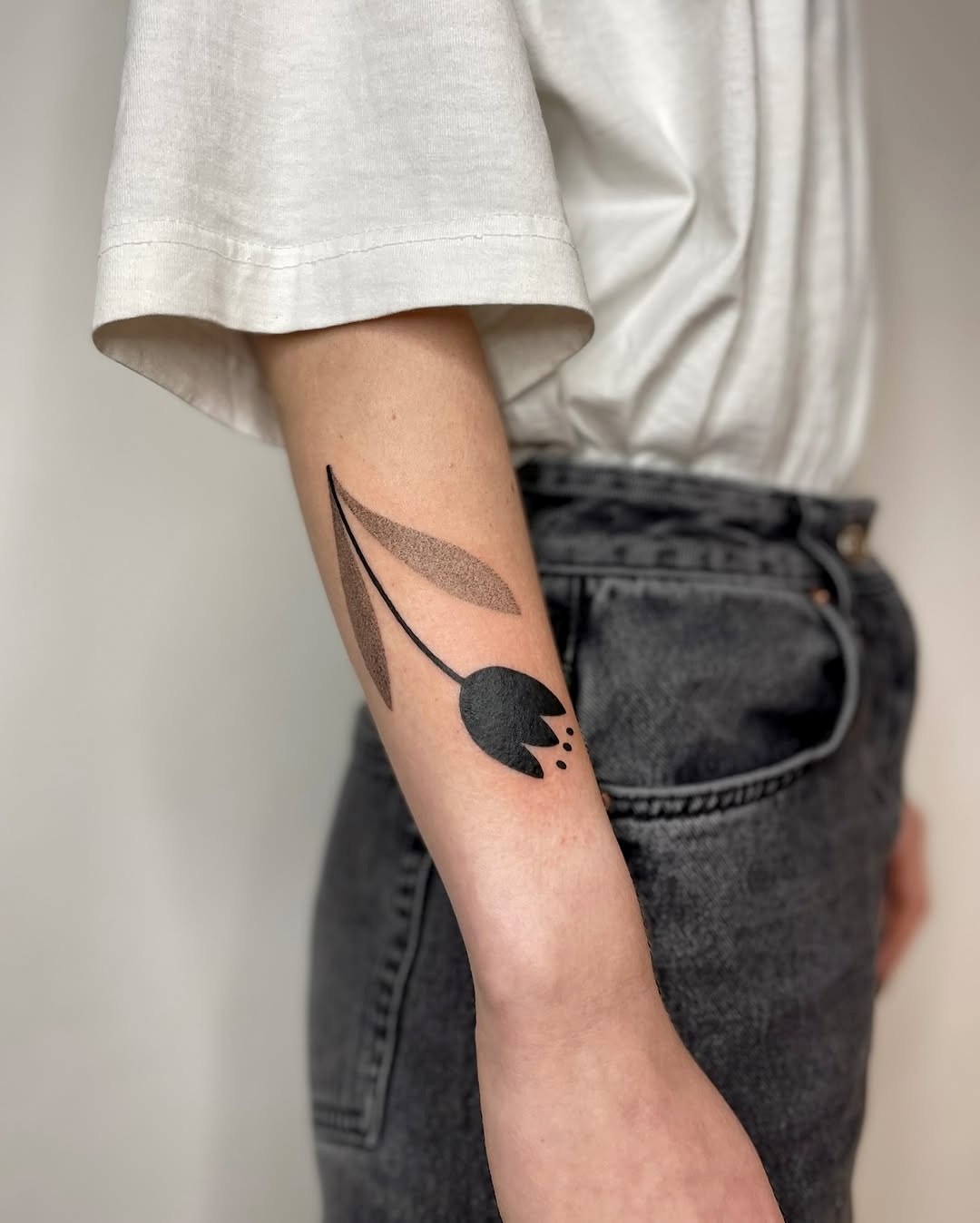Stylish black tulip tattoo on the arm