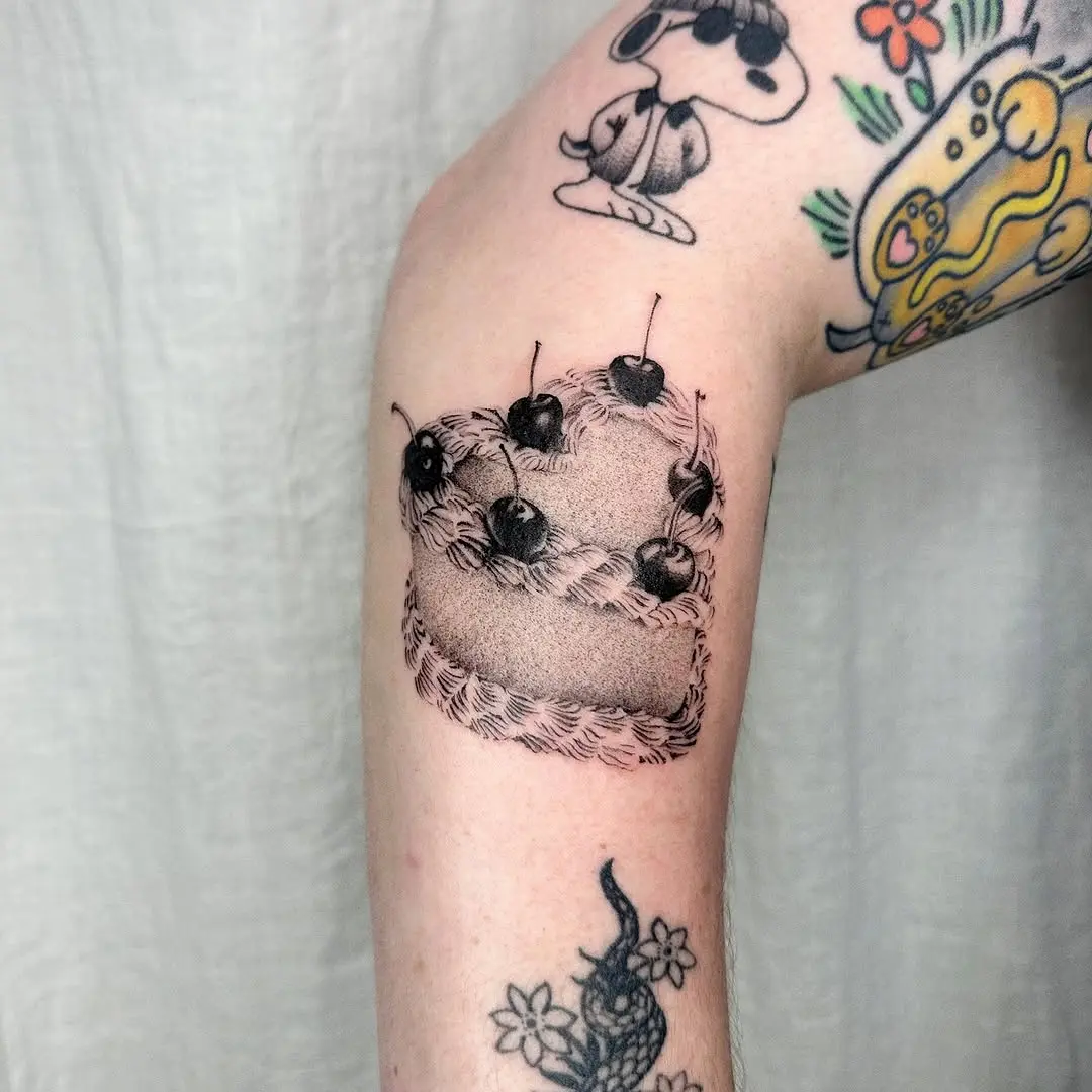 Charming cake tattoo with cherries on top