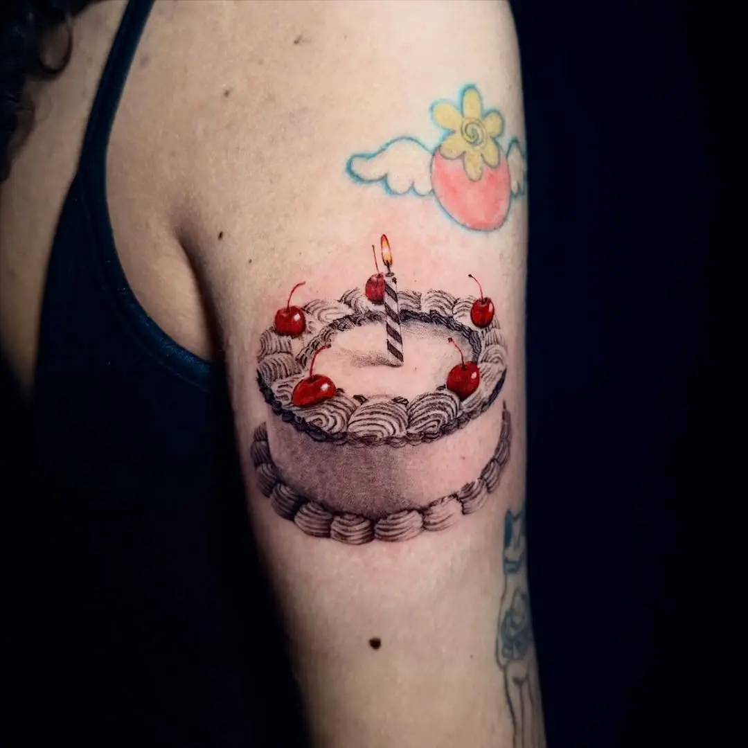 Whimsical cake tattoo with vibrant cherries