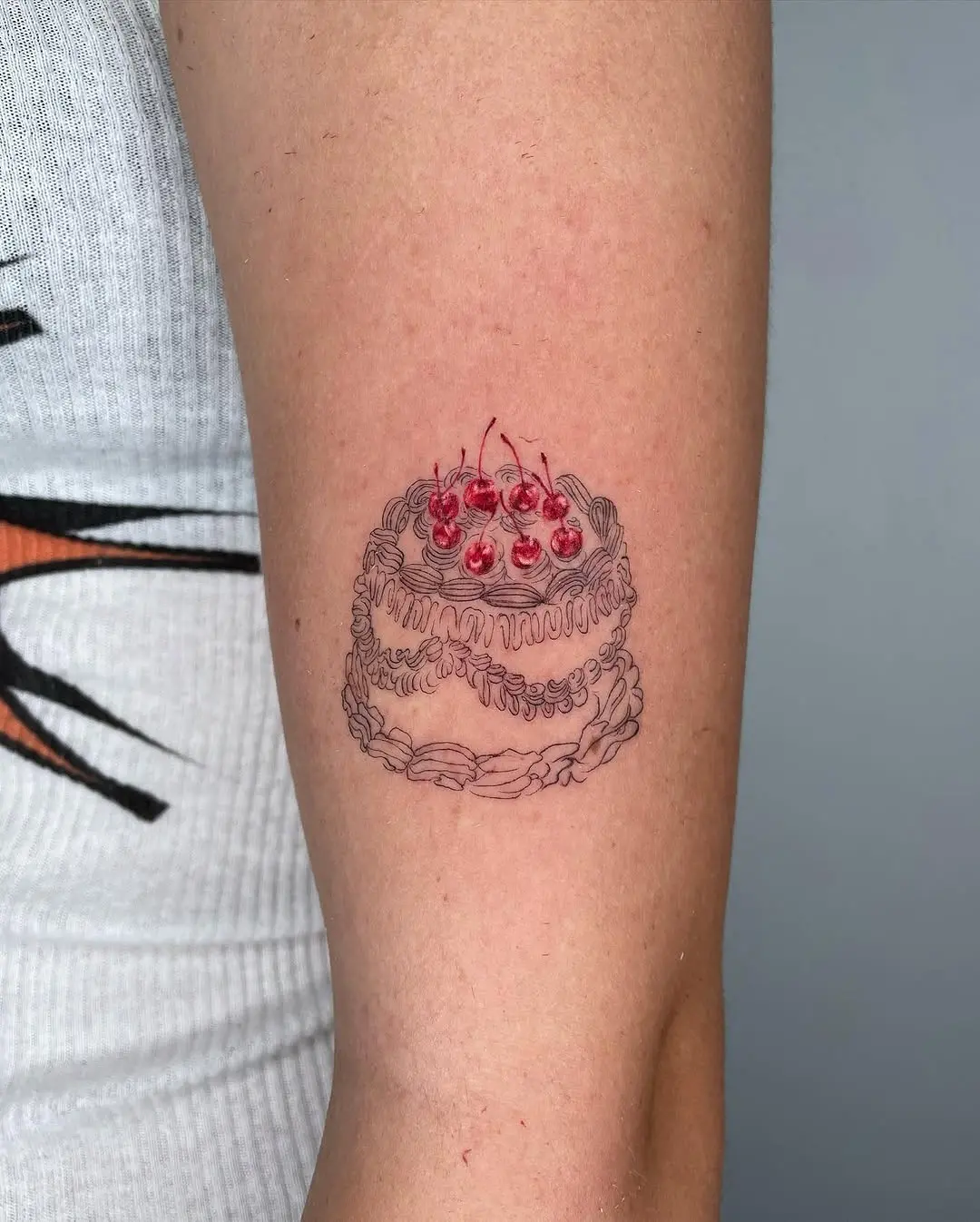 Charming cake tattoo with cherries on top