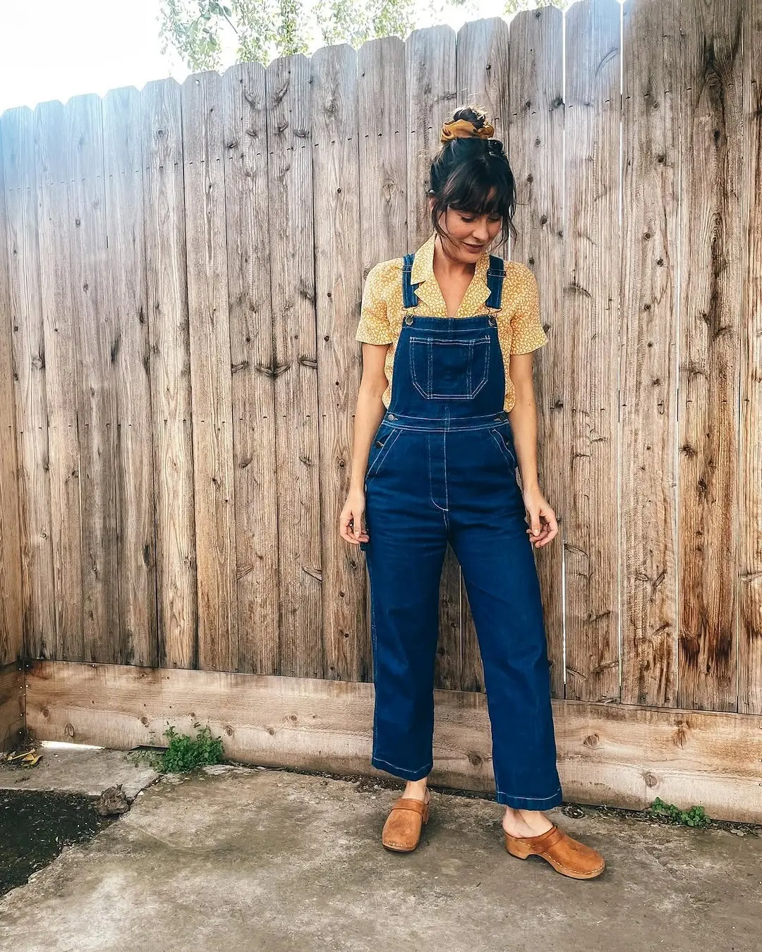 Stylish denim overalls paired with floral blouse