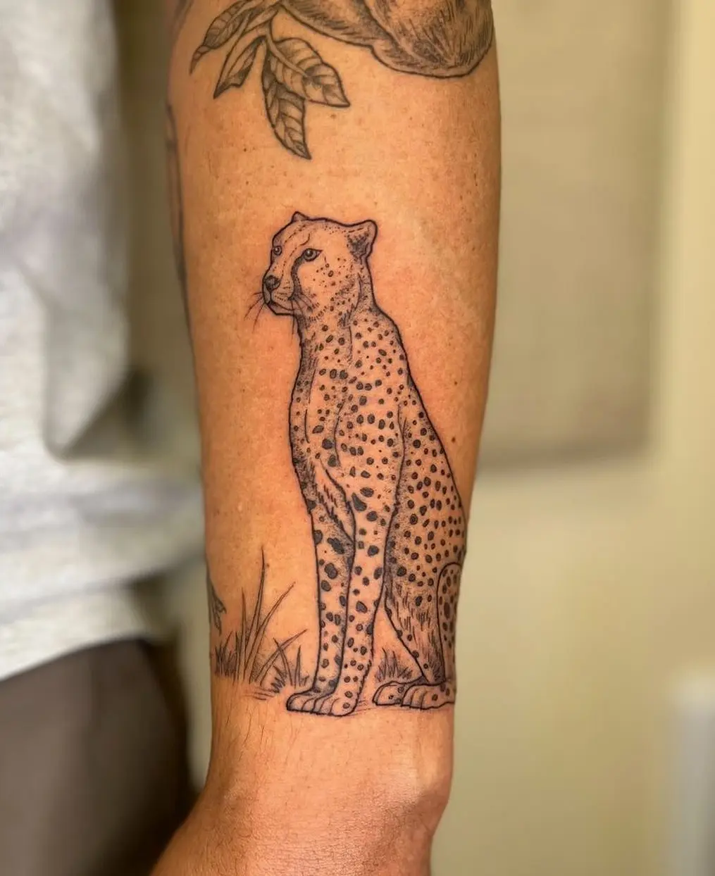 Elegant black ink cheetah tattoo on arm