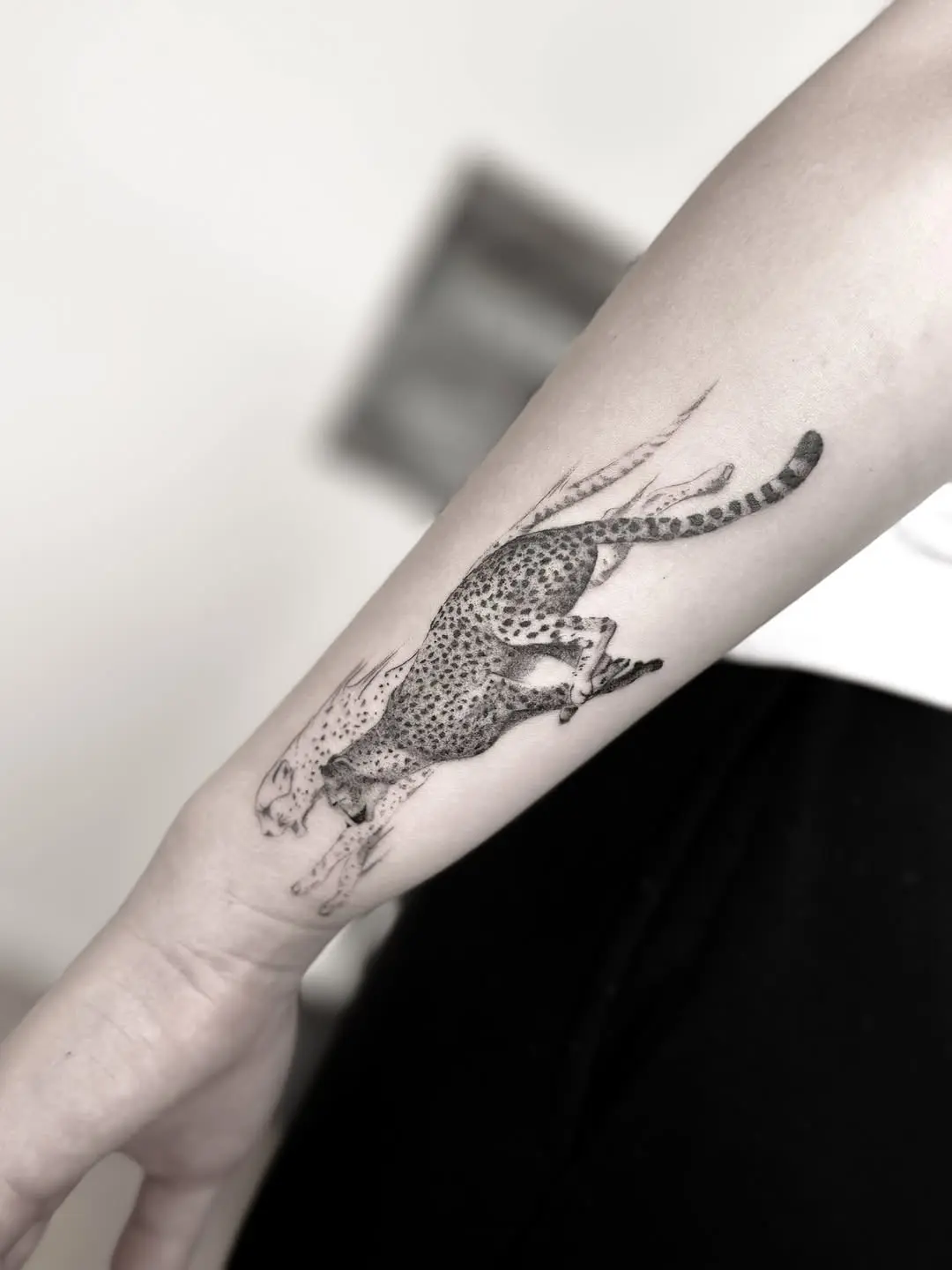 Stylish leaping cheetah tattoo in fine detail