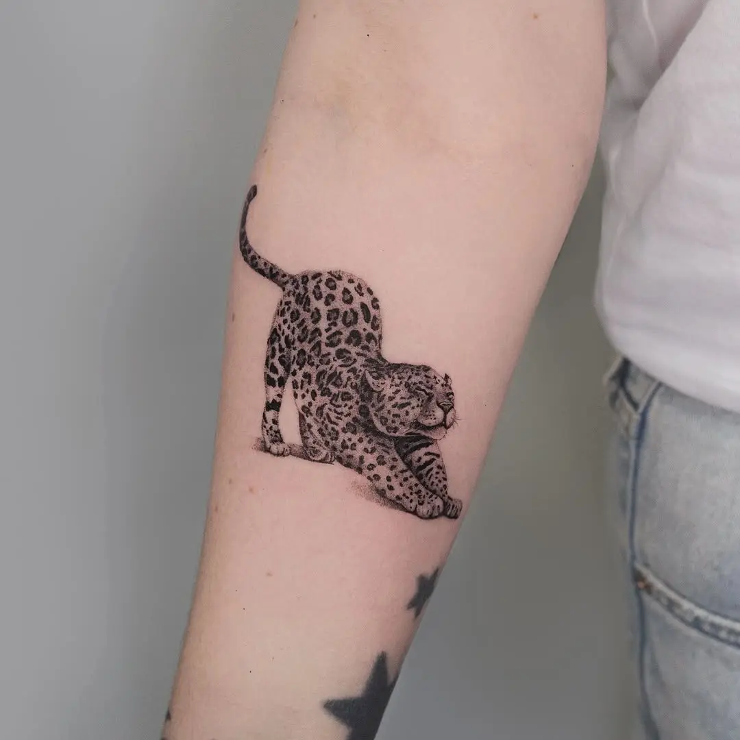 Dynamic cheetah tattoo in striking black ink
