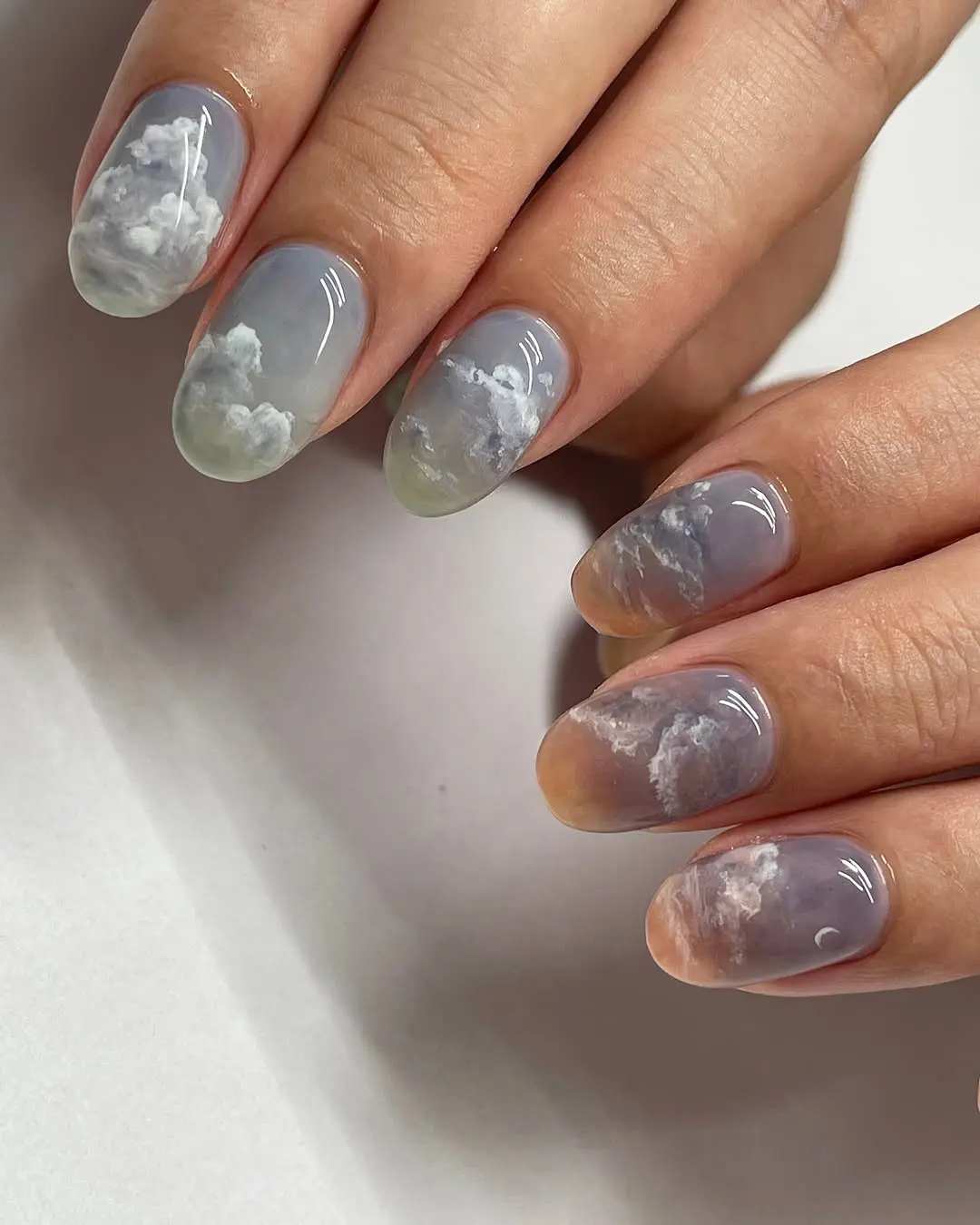 Whimsical cloud designs on dreamy gradient nails