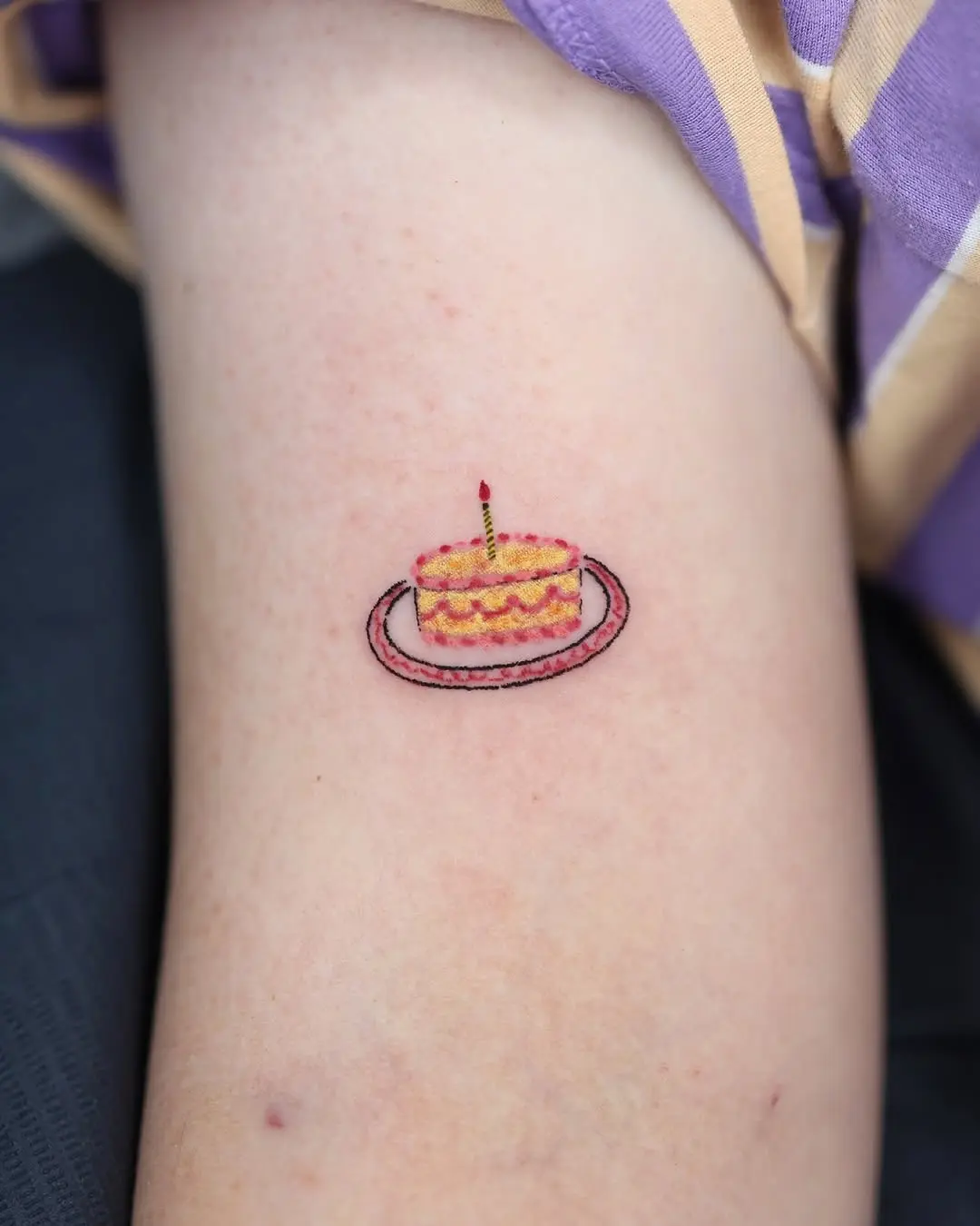 Vibrant cake tattoo with a whimsical touch
