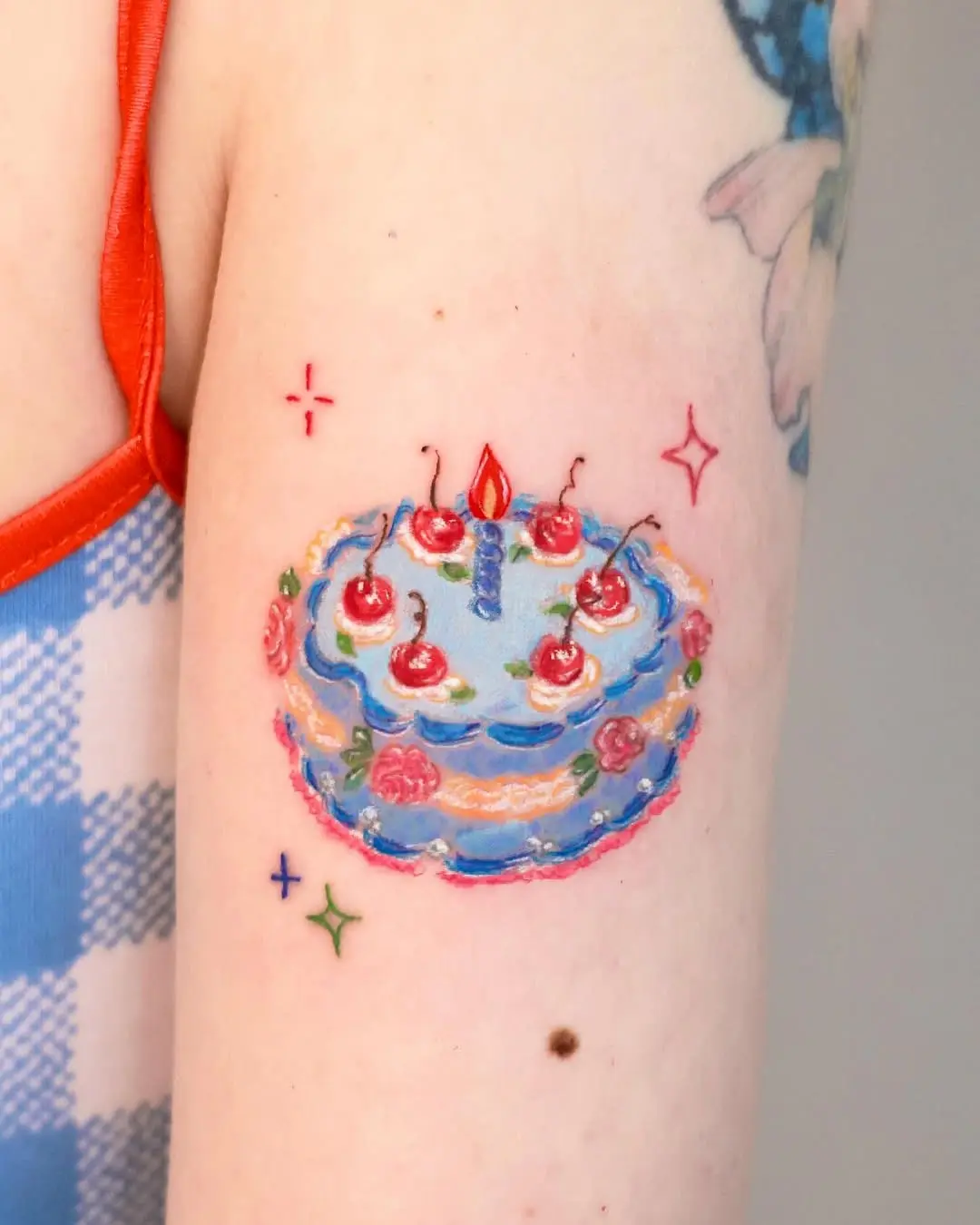 Playful cake tattoo with vibrant colors