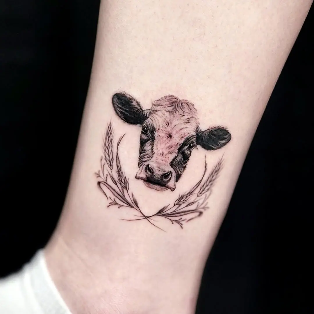 Intricate cow head tattoo with floral accents
