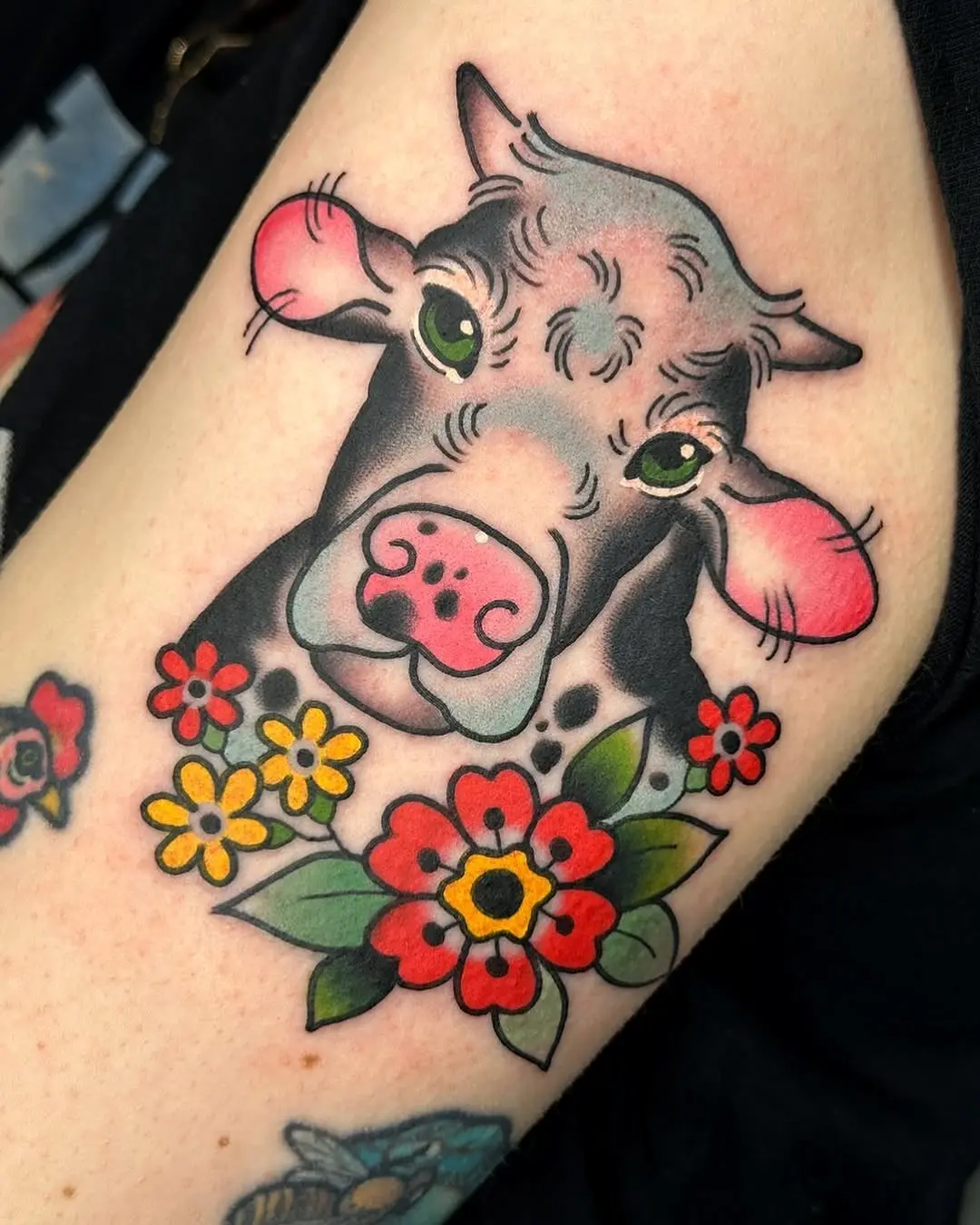 Colorful cow tattoo with floral accents