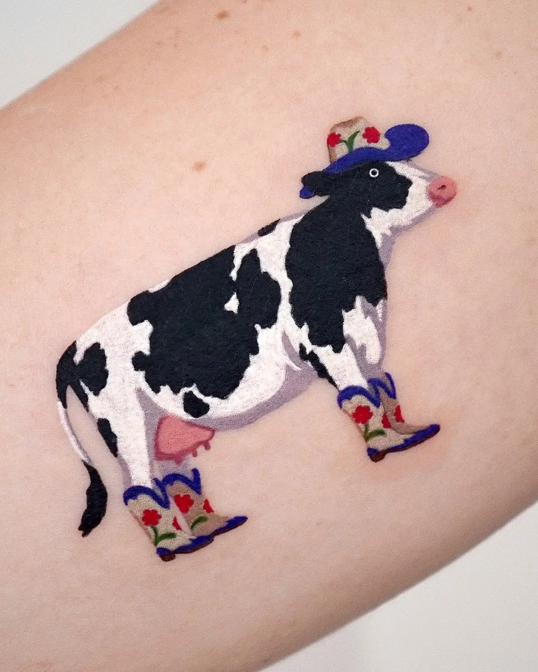 Whimsical Cow Tattoo in Cowboy Attire
