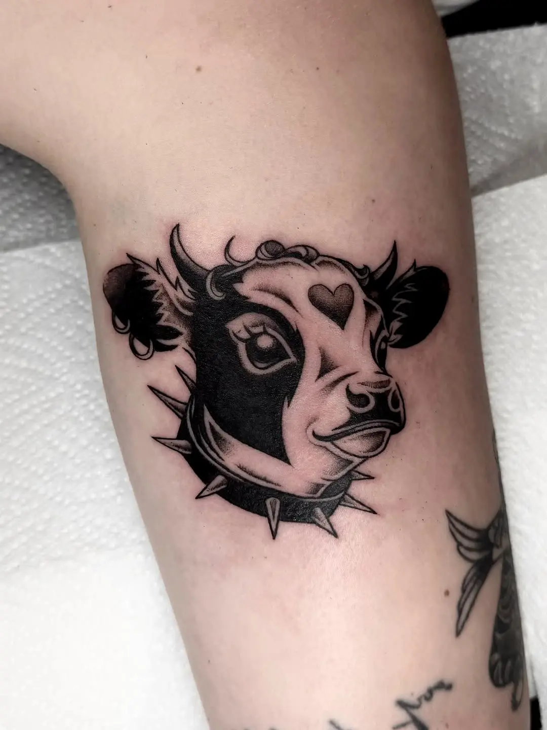 Charming cow tattoo with a punk twist