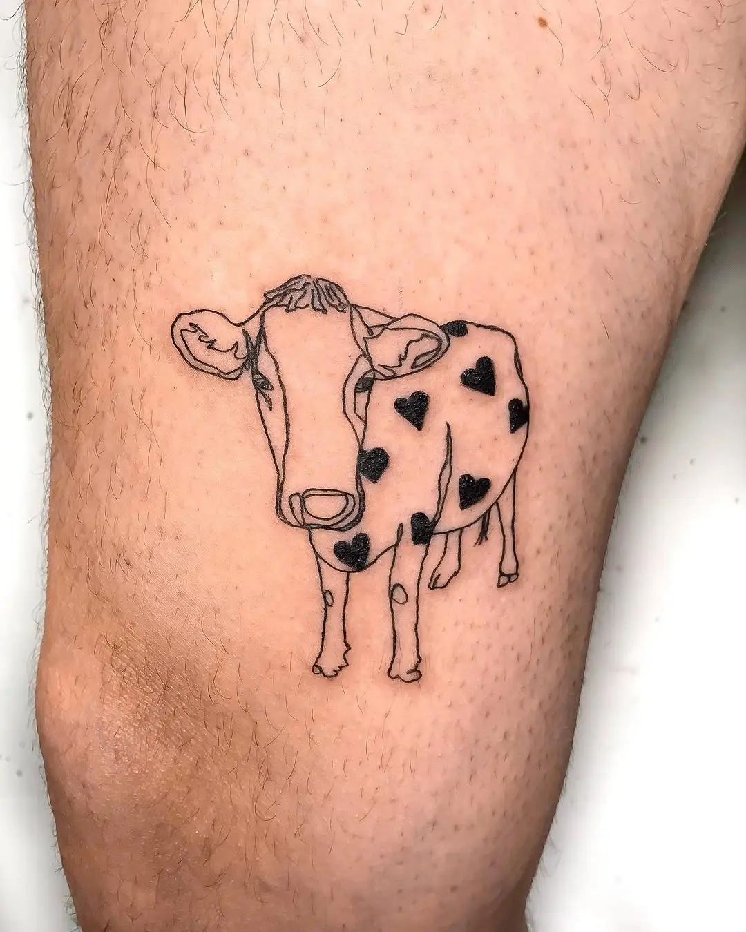 Charming cow tattoo with heart patterns