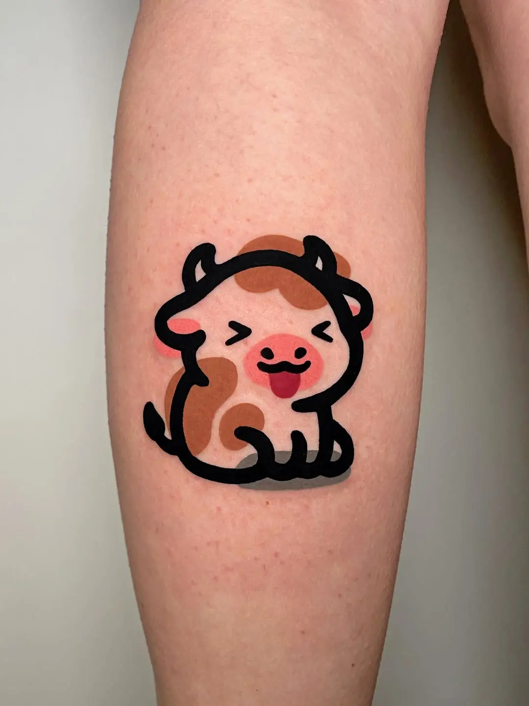 Whimsical cow character tattoo with vibrant colors