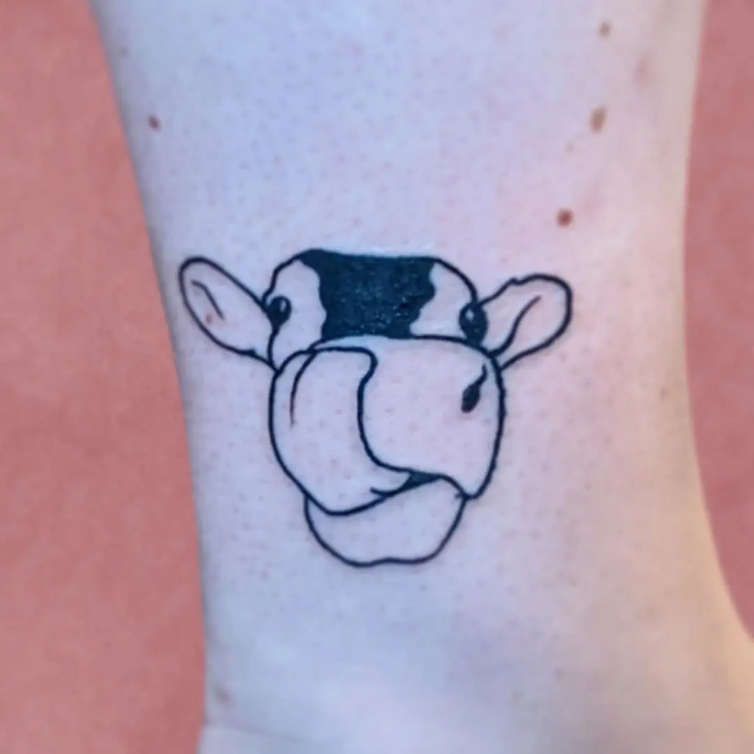 Adorable cow tattoo for cheerful vibes