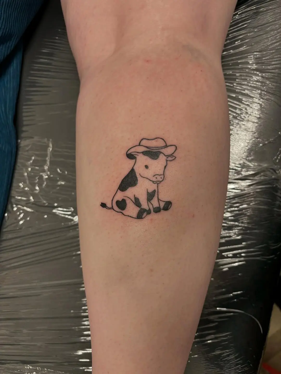 Adorable cow tattoo with a playful vibe