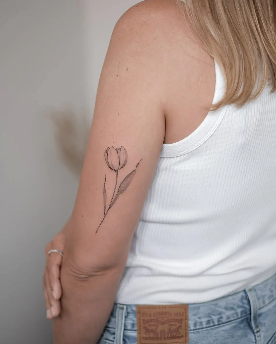 Delicate tulip tattoo on a woman's arm