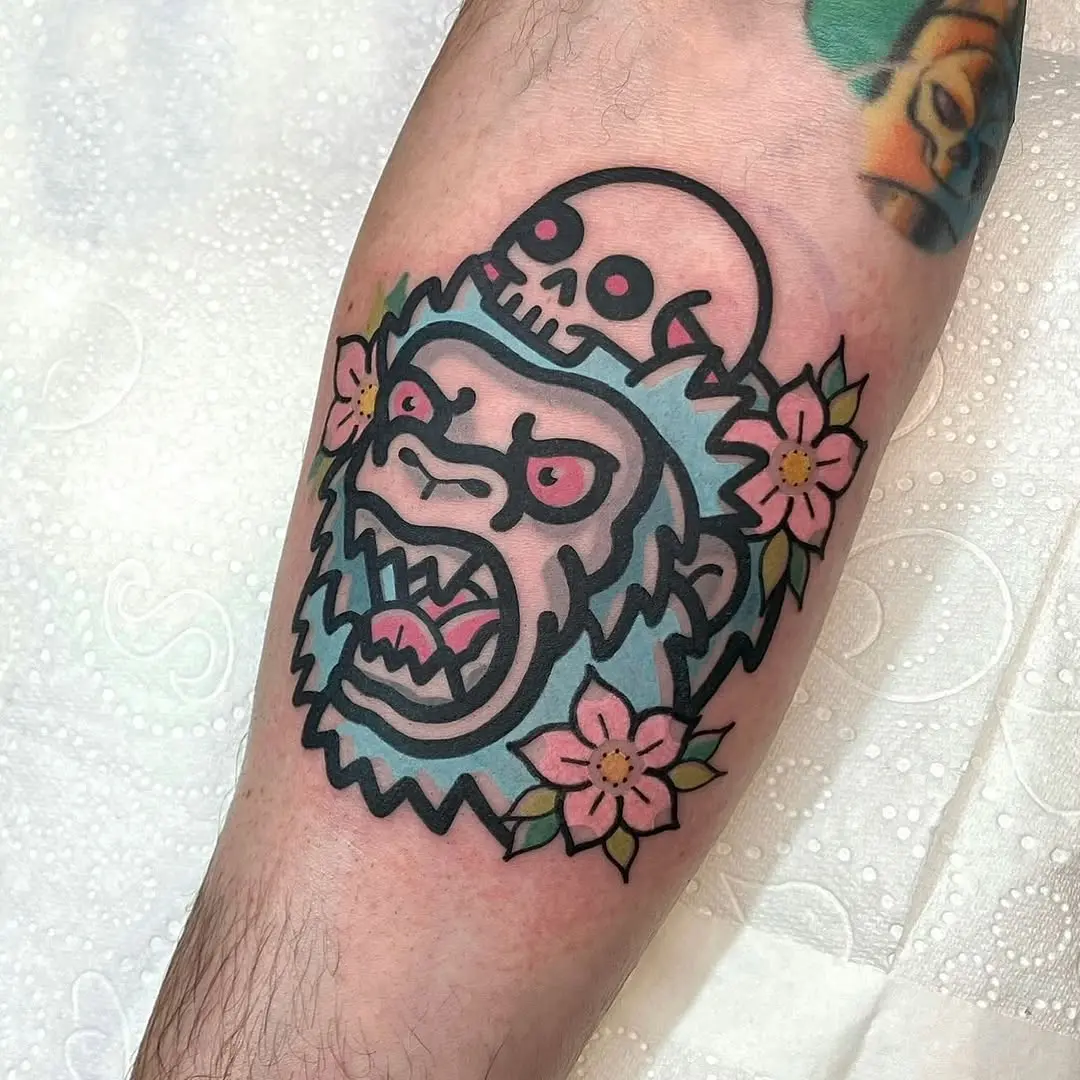 Vibrant gorilla with skull and flowers tattoo