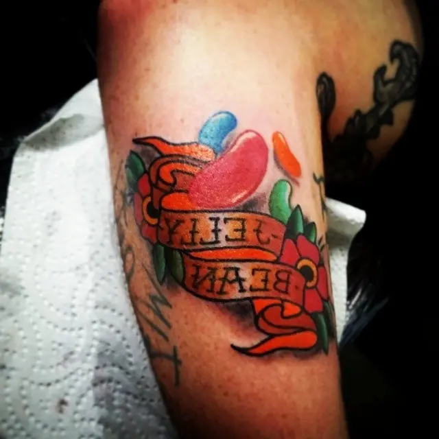 Colorful jelly bean tattoo with a vibrant ribbon