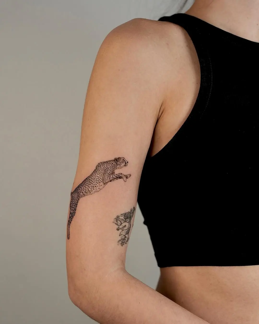 Dynamic cheetah tattoo in mid-leap