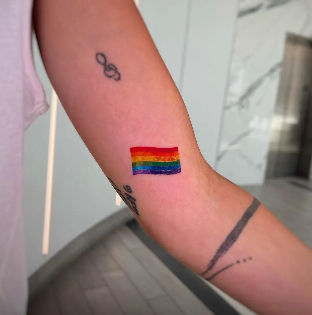 Vibrant rainbow flag tattoo on arm