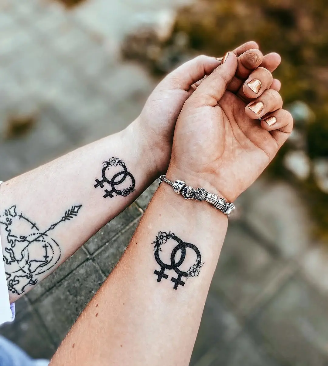 Charming LGBTQ+ female symbol tattoos on wrists