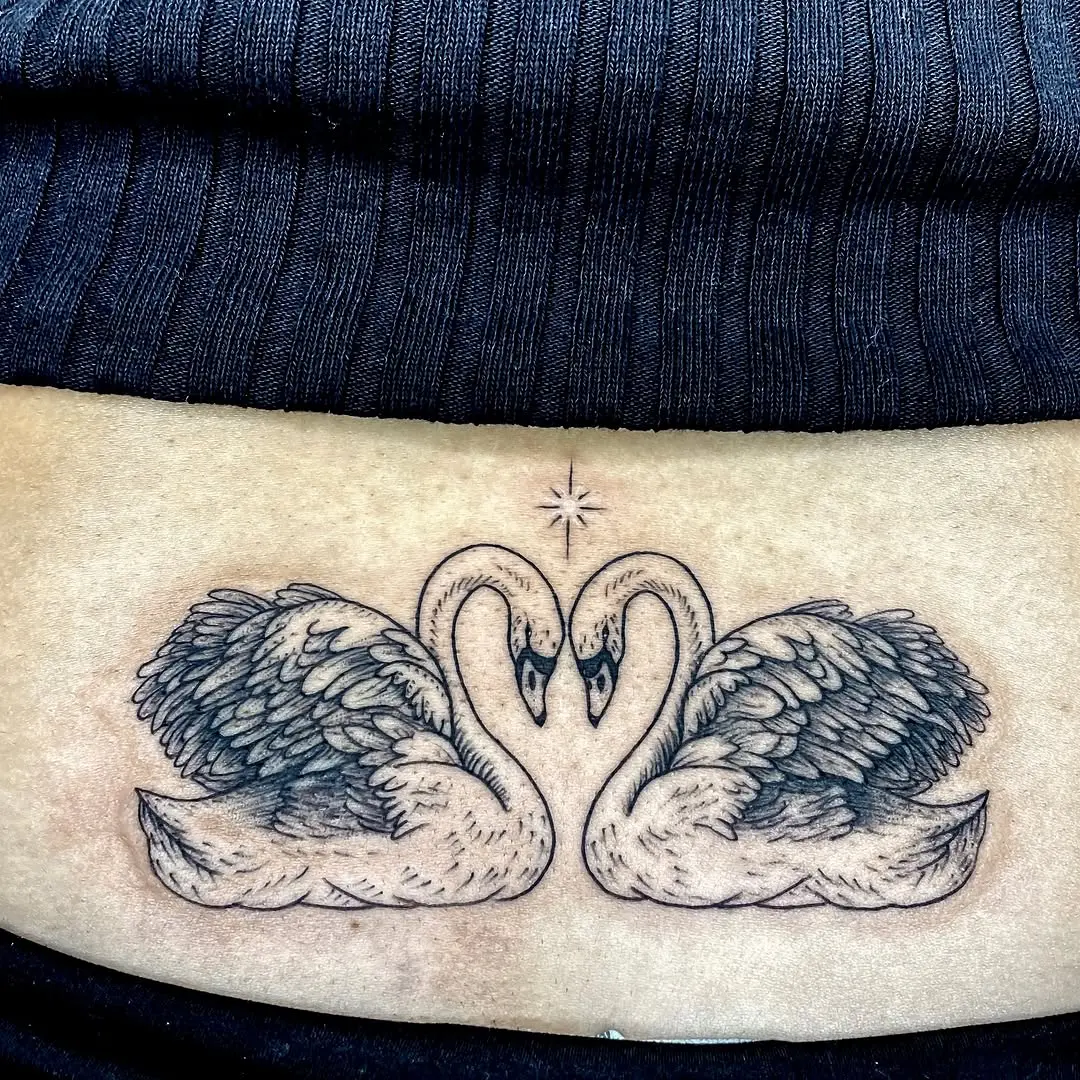 Stunning swan tattoo as a lower back centerpiece