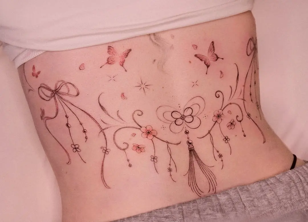Delicate floral and butterfly lower back tattoo art