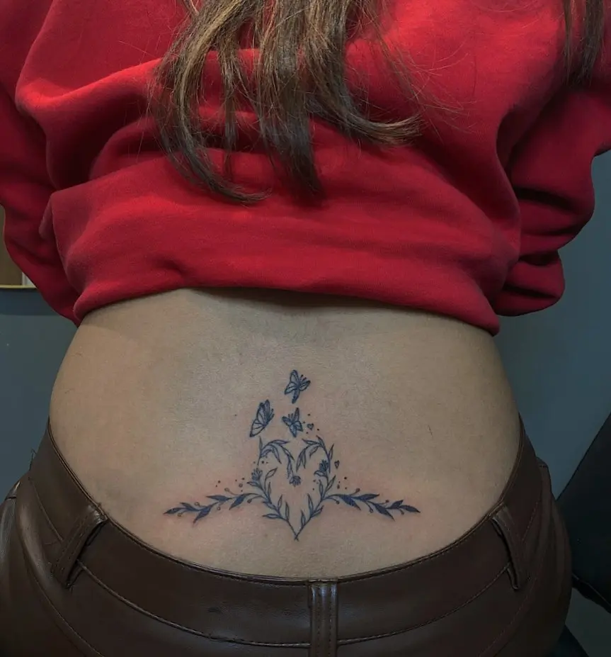 Charming floral lower back tattoo with butterflies