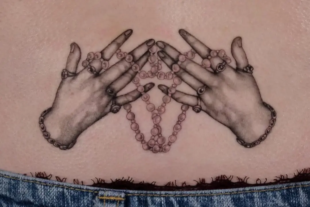 Intricately Detailed Hands Holding Beaded Necklace