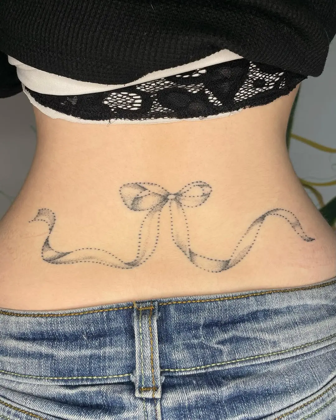 Elegant ribbon tattoo on lower back