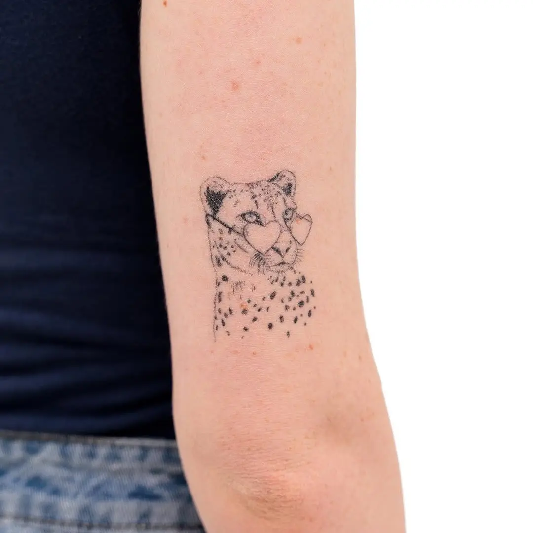 Stylish cheetah head tattoo with heart-shaped glasses