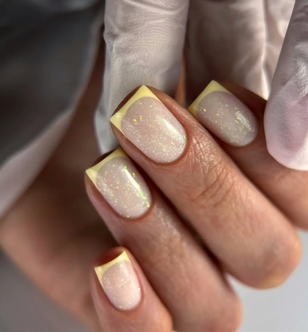 Chic nails with pastel yellow tips and sparkle