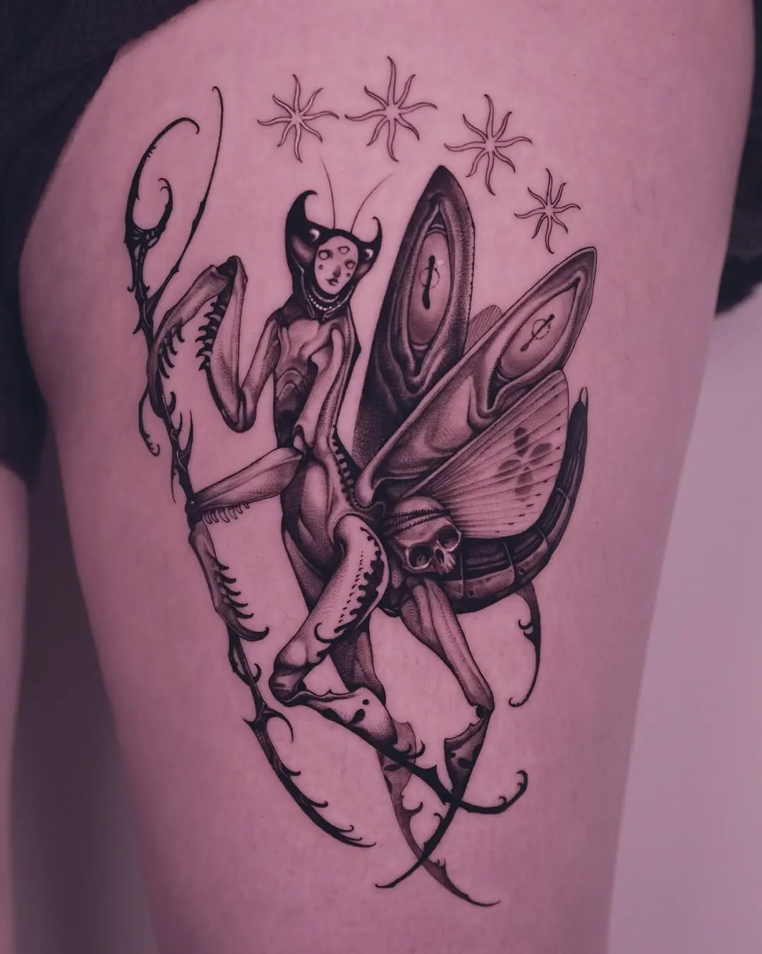 Intricate praying mantis tattoo with celestial touch