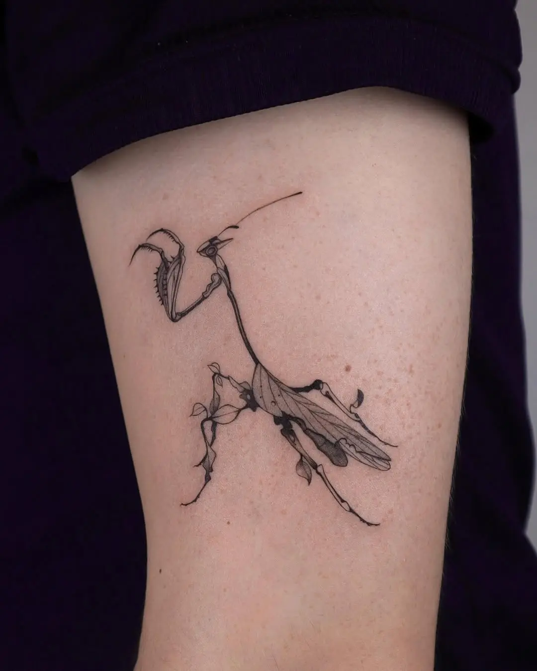 Elegant praying mantis tattoo with floral details