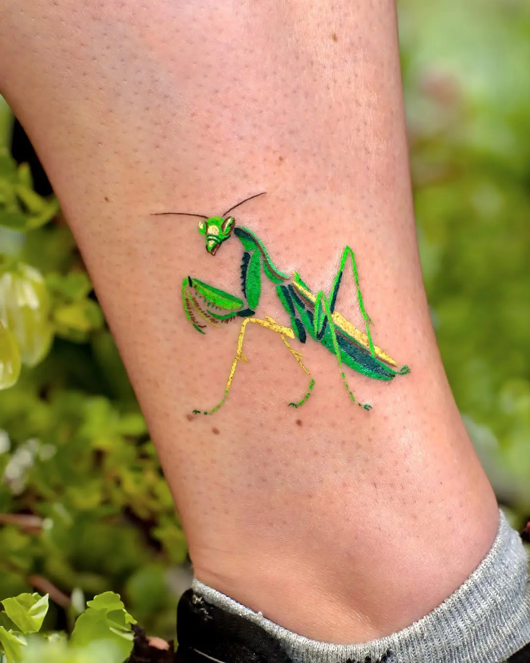 Stunning green praying mantis leg tattoo design