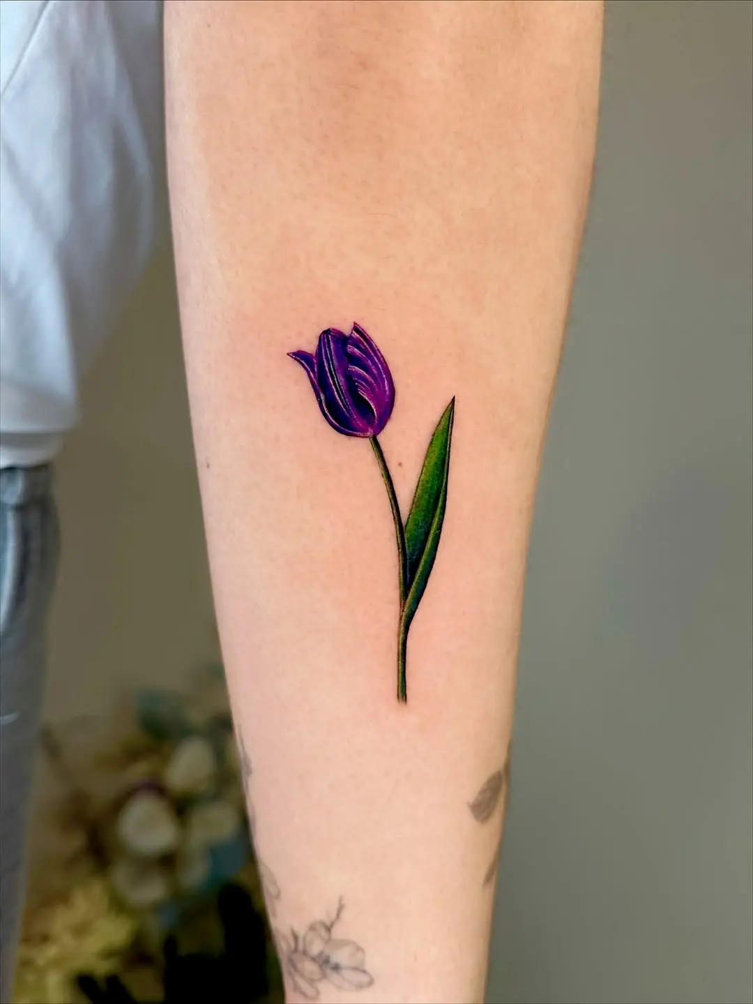 Elegant purple tulip tattoo on forearm
