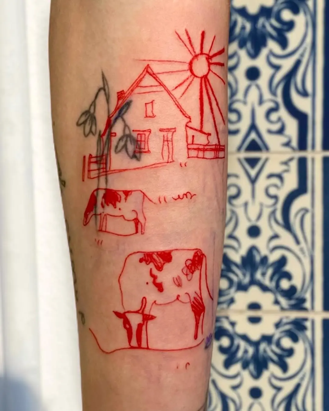 Charming red cow tattoo with a farmhouse