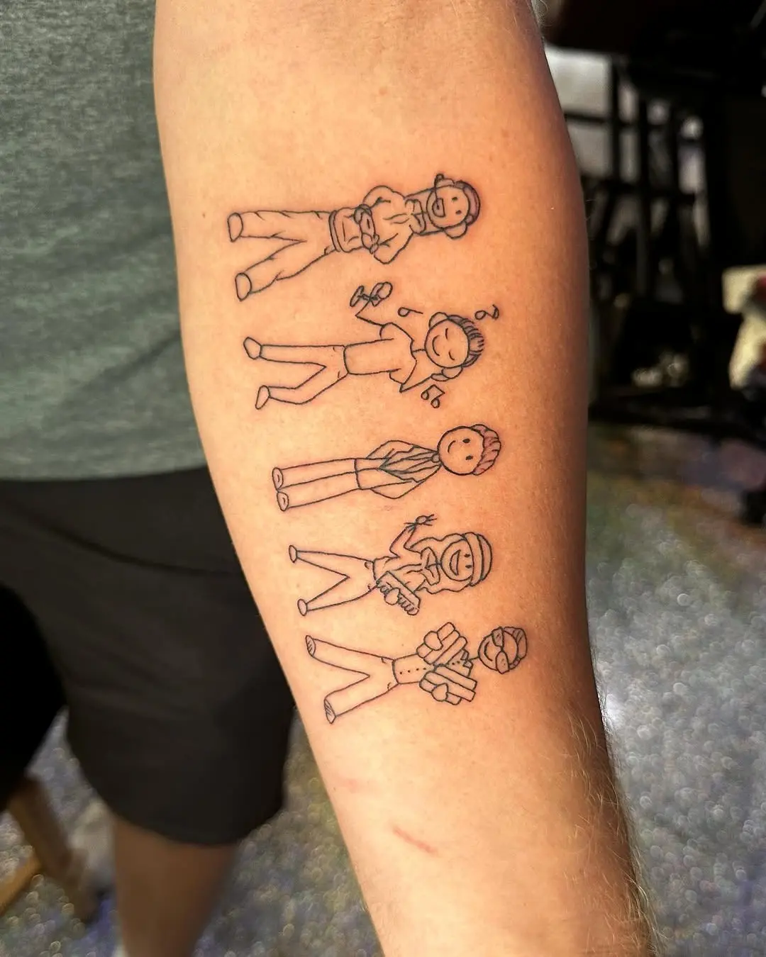 Playful stick figure tattoo designs on arm