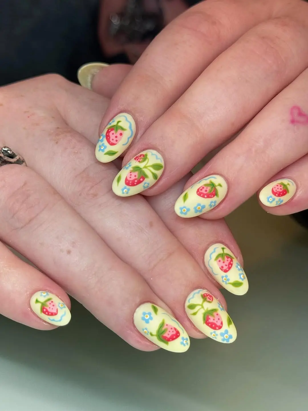 Vibrant Strawberry Nail Art on a Light Background