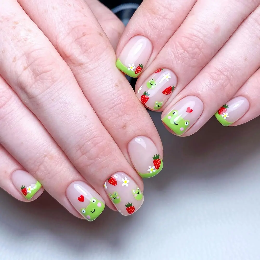 Charming strawberry nails with playful frog accents