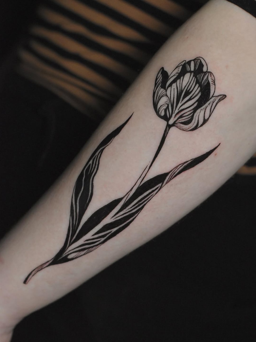 Elegant black line art tulip tattoo design