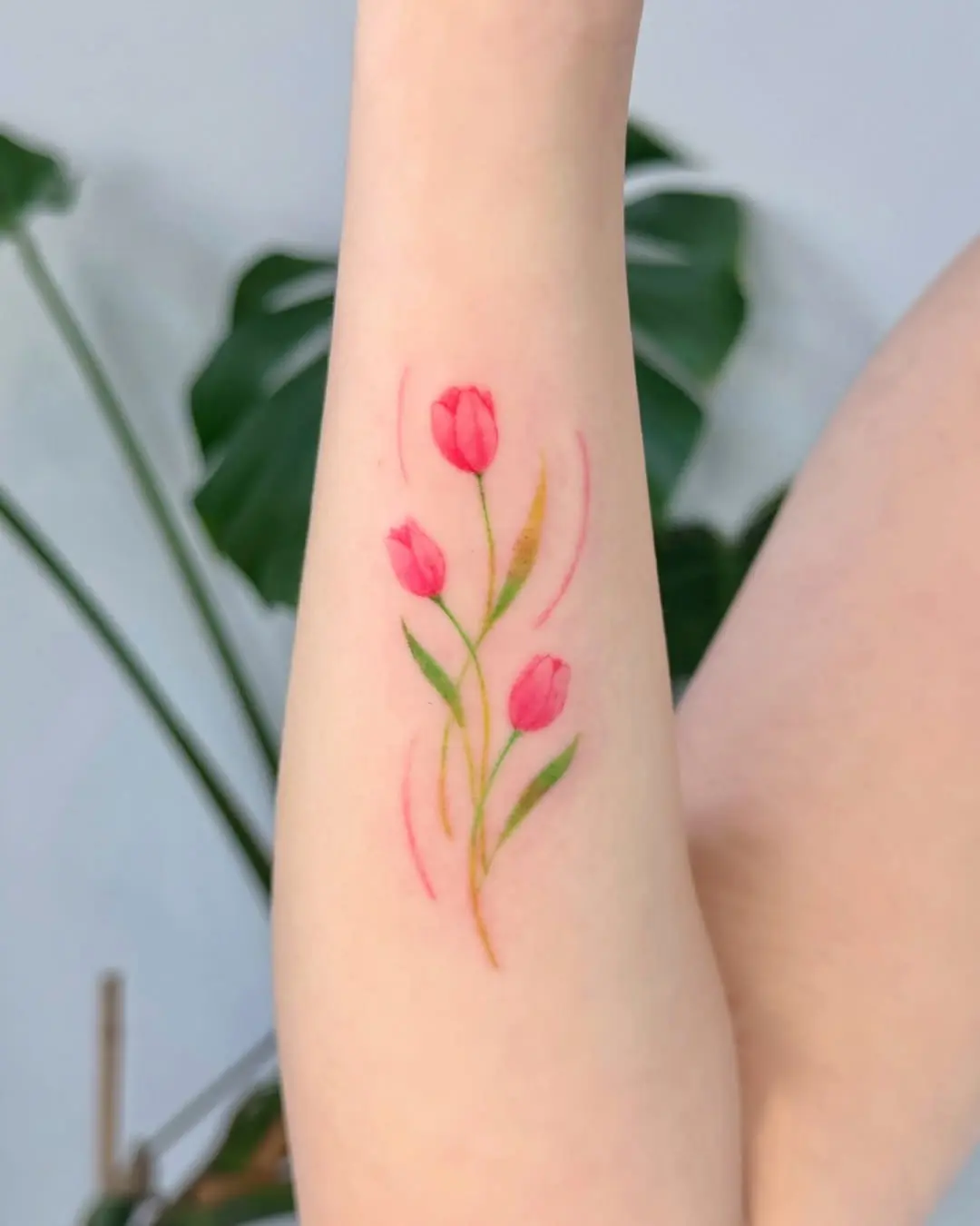 Delicate tulip tattoo on a graceful forearm