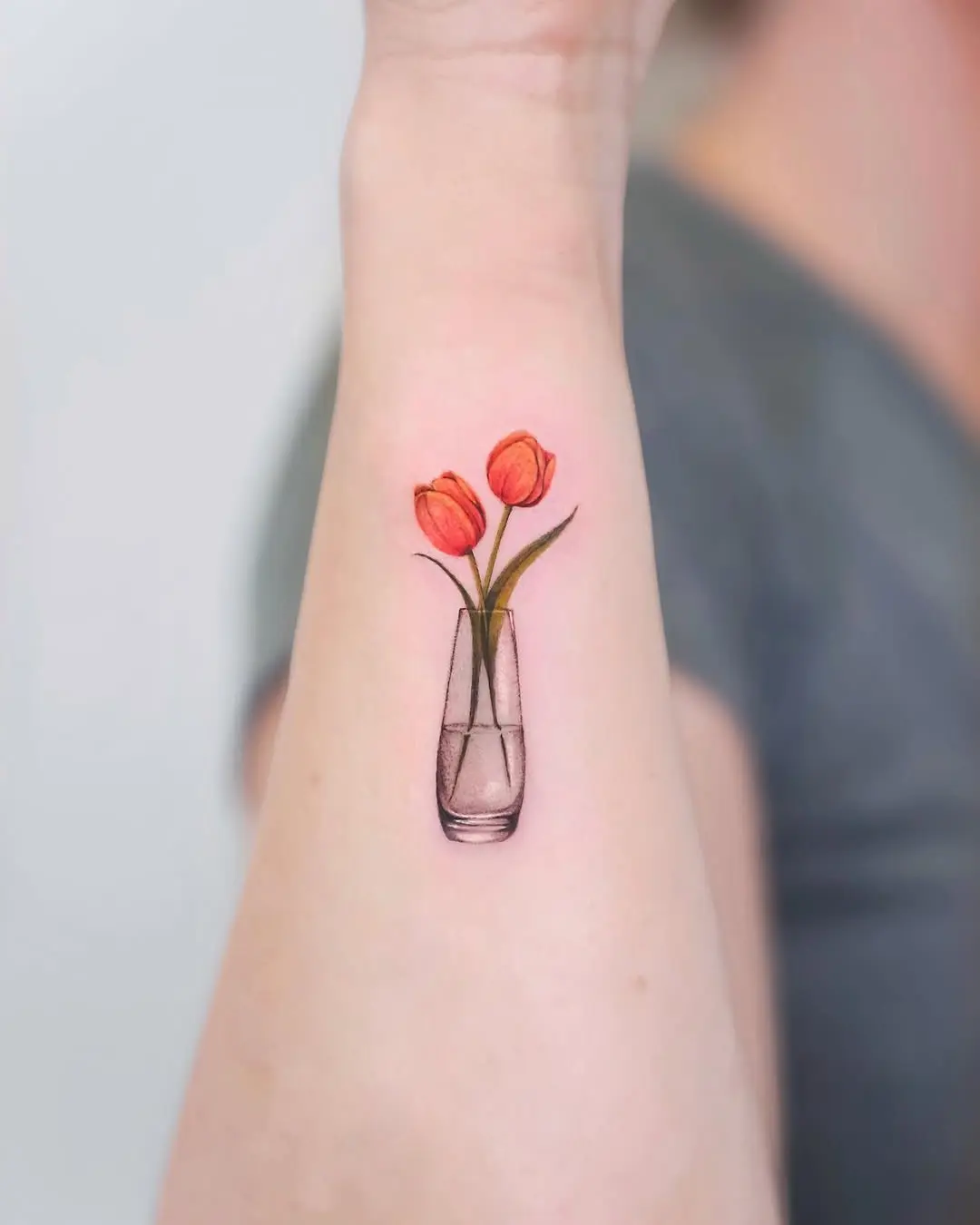 Charming tulip tattoo in a vase design