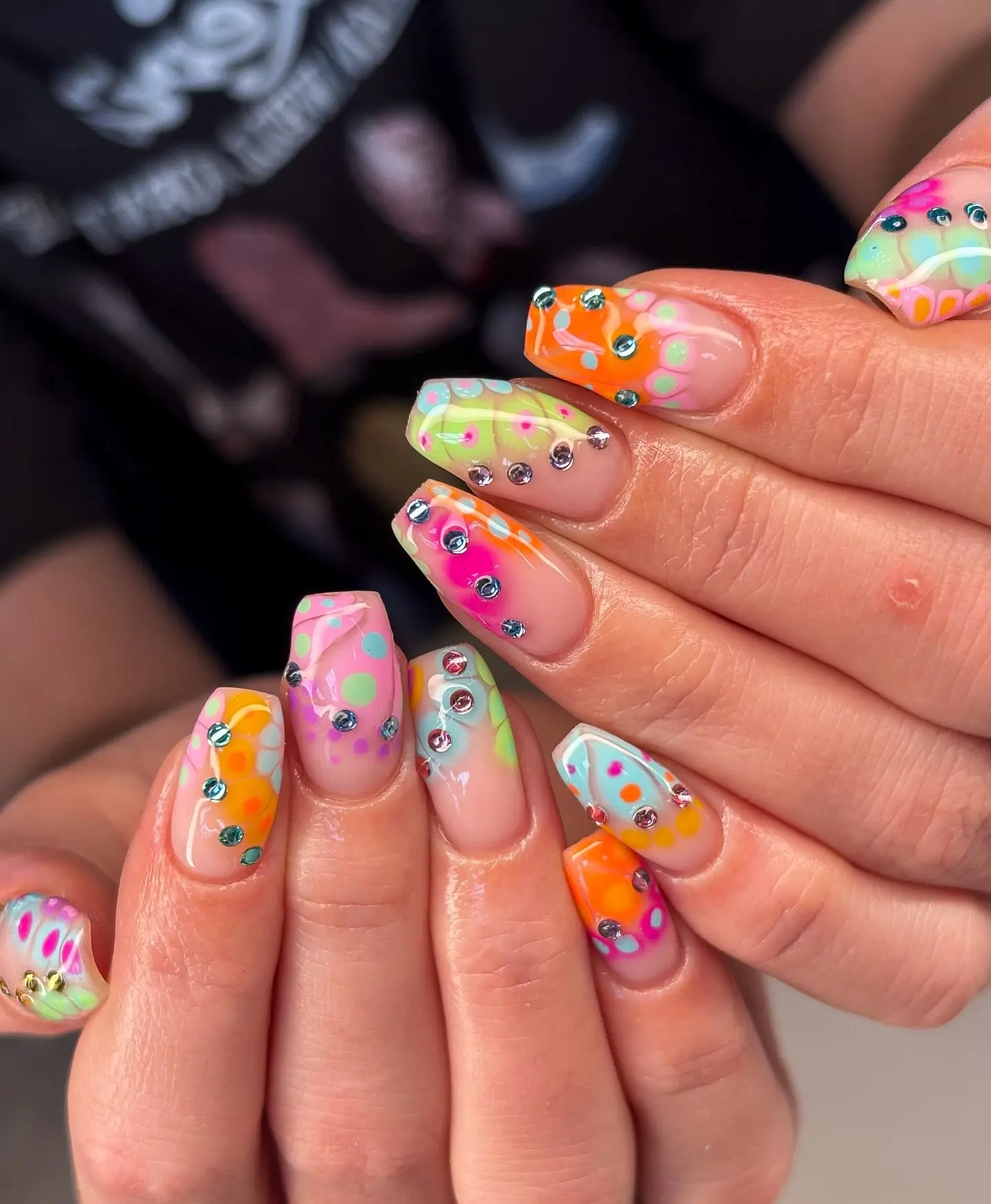Vibrant unicorn-inspired nail art with gems